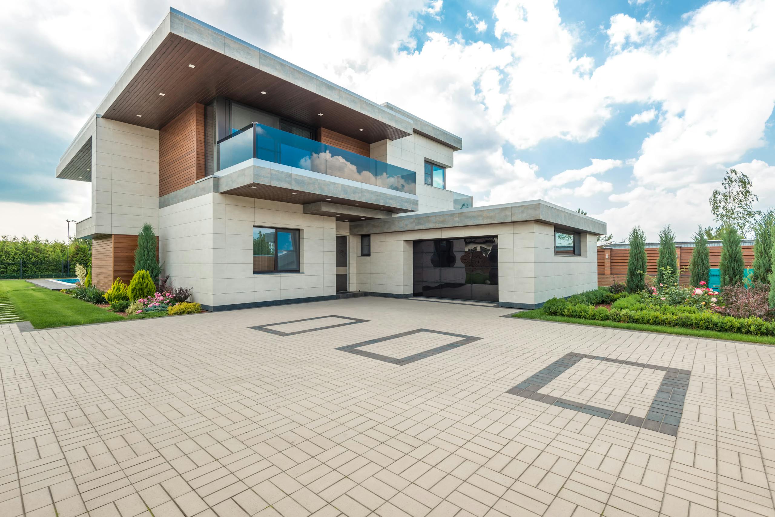 Elegant modern house exterior with lush greenery and ample driveway space.